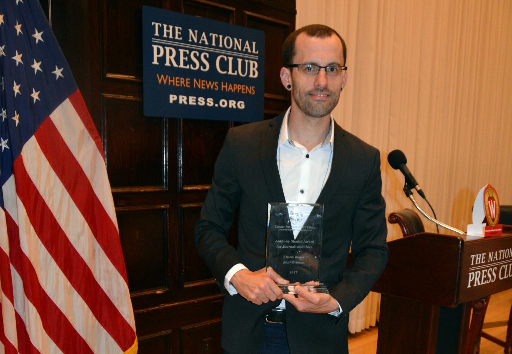 Shane Bauer holding the Anthony Shadid Award for Journalism Ethics at the 2017 award ceremony at the National Press Club in Washington, DC.